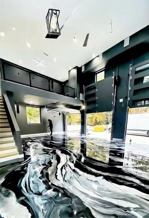 Black and white swirled metallic epoxy floor in a two-story garage